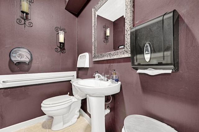 bathroom with toilet and tile patterned floors