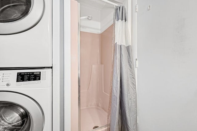 bathroom featuring walk in shower and stacked washer and clothes dryer