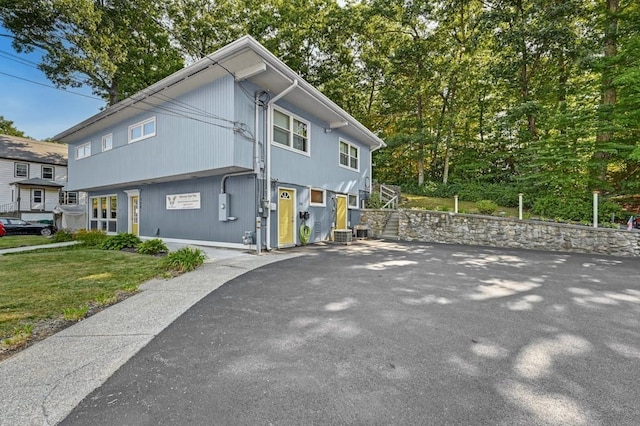 view of property exterior with a lawn and central AC