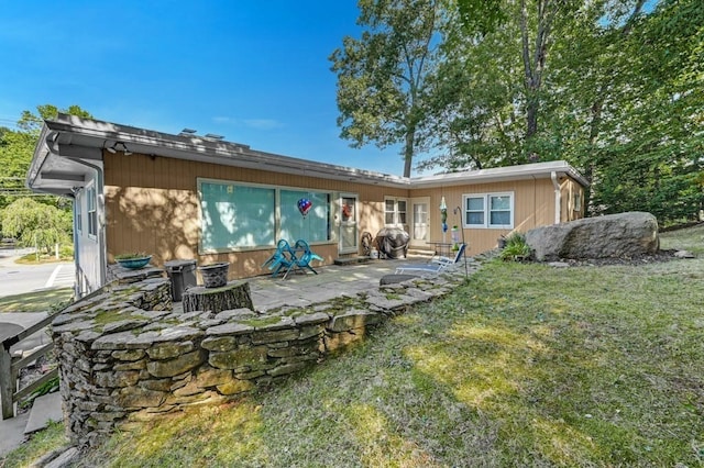 back of property with a patio area and a yard