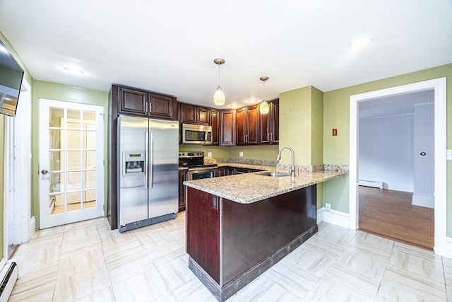 kitchen featuring kitchen peninsula, sink, decorative light fixtures, light stone counters, and stainless steel appliances