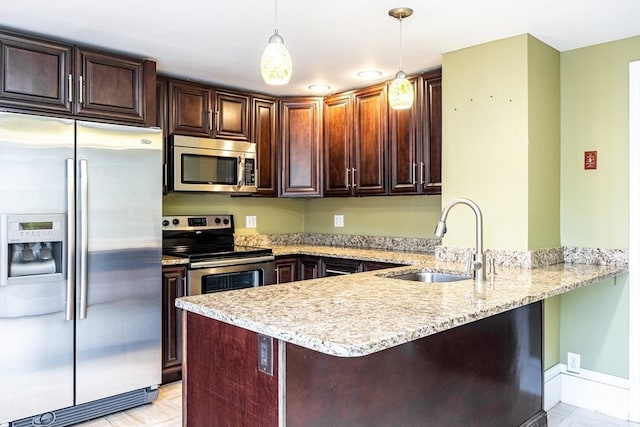 kitchen featuring pendant lighting, kitchen peninsula, appliances with stainless steel finishes, and sink