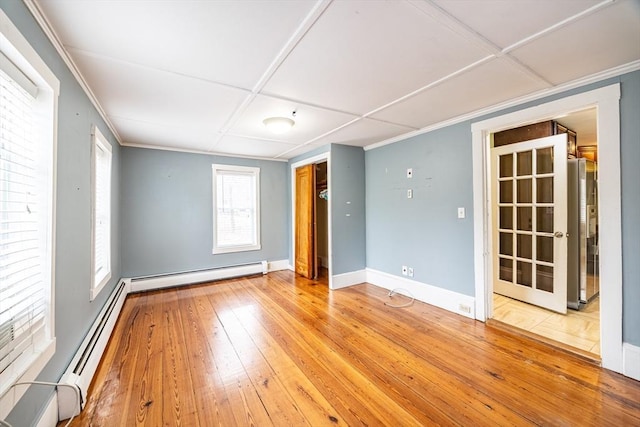 unfurnished room featuring hardwood / wood-style flooring, coffered ceiling, and a baseboard radiator