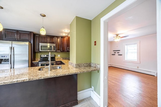 kitchen with a baseboard radiator, dark brown cabinetry, decorative light fixtures, stainless steel appliances, and light stone counters