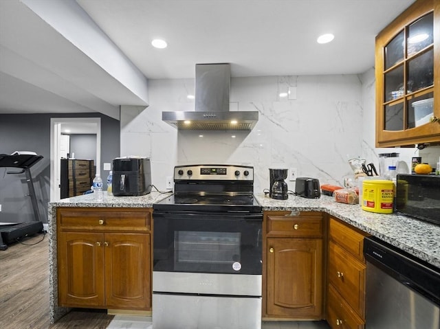 22 2nd Ave, Leominster, MA 01453 - kitchen featuring wall chimney range hood, stainless steel appliances, glass insert cabinets, brown cabinetry, and light wood-style flooring
