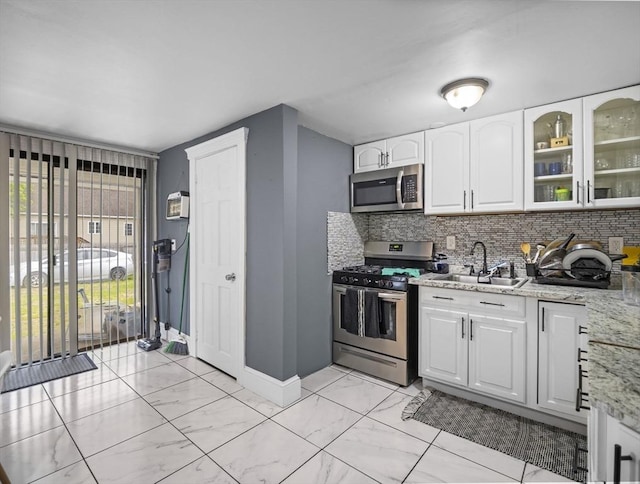 22 2nd Ave, Leominster, MA 01453 - kitchen with appliances with stainless steel finishes, a sink, light marble finish flooring, and tasteful backsplash
