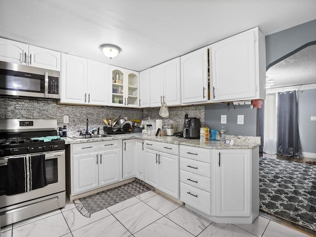 22 2nd Ave, Leominster, MA 01453 - kitchen with appliances with stainless steel finishes, a sink, tasteful backsplash, and light stone countertops