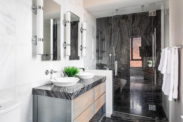 bathroom featuring vanity, toilet, an enclosed shower, and tile walls