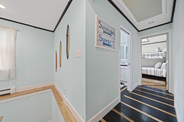 hallway featuring hardwood / wood-style floors, crown molding, and a baseboard radiator