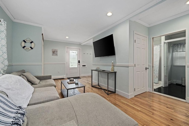 living room with baseboard heating, ornamental molding, and hardwood / wood-style floors