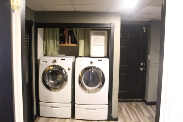 washroom with washer and clothes dryer and light hardwood / wood-style floors