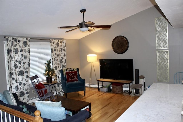 living room featuring ceiling fan, hardwood / wood-style floors, a baseboard radiator, and vaulted ceiling