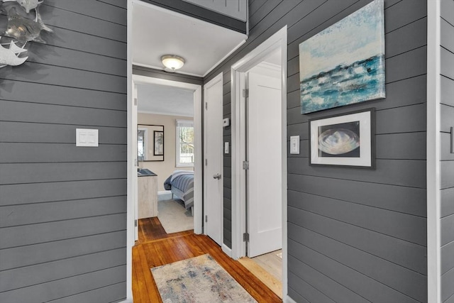 corridor featuring wood finished floors and ornamental molding