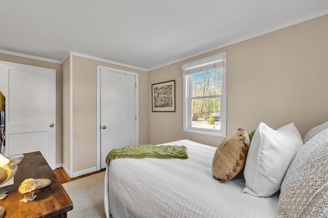 bedroom featuring baseboards, wood finished floors, and ornamental molding