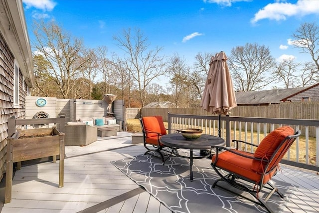 deck featuring a fenced backyard, outdoor dining space, and an outdoor hangout area