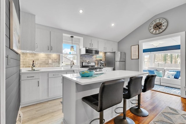 kitchen featuring lofted ceiling, light countertops, light wood-style floors, and appliances with stainless steel finishes