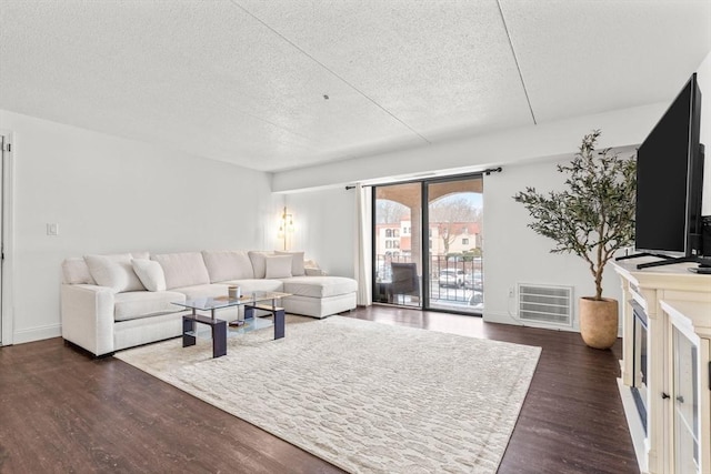 living room with dark wood-type flooring and a textured ceiling