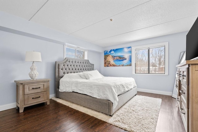 bedroom with multiple windows and dark wood-type flooring