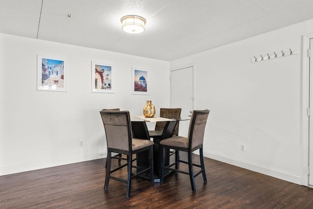 dining room featuring dark hardwood / wood-style floors and a textured ceiling