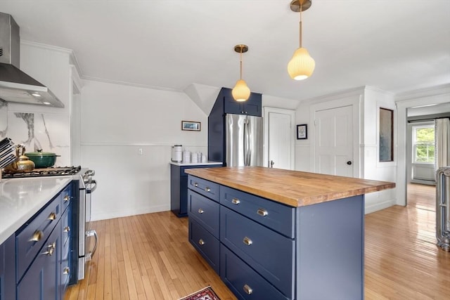 35 Ocean Ave Unit 3, Salem, MA 01970 - kitchen featuring blue cabinetry, butcher block counters, wall chimney exhaust hood, stainless steel appliances, and ornamental molding