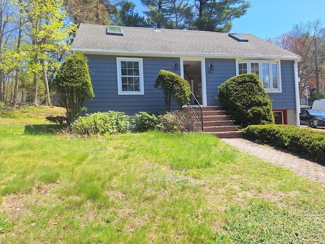 view of front of home with roof with shingles and a front lawn