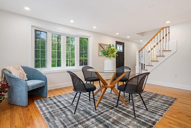 dining area with recessed lighting, wood finished floors, baseboards, and stairs