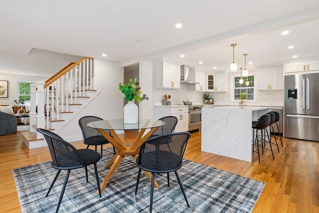 dining area featuring recessed lighting, light wood-type flooring, baseboards, and stairs