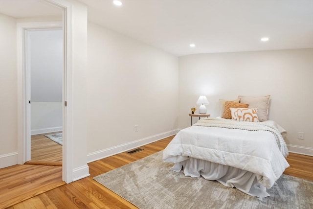 bedroom featuring light wood-type flooring, recessed lighting, baseboards, and visible vents