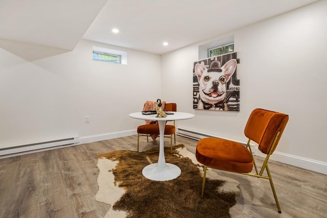 living area with baseboards, baseboard heating, recessed lighting, and wood finished floors