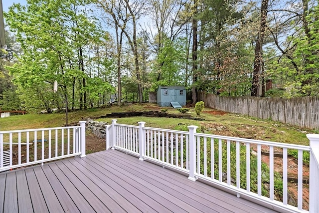 deck featuring an outbuilding, fence, a lawn, and a shed