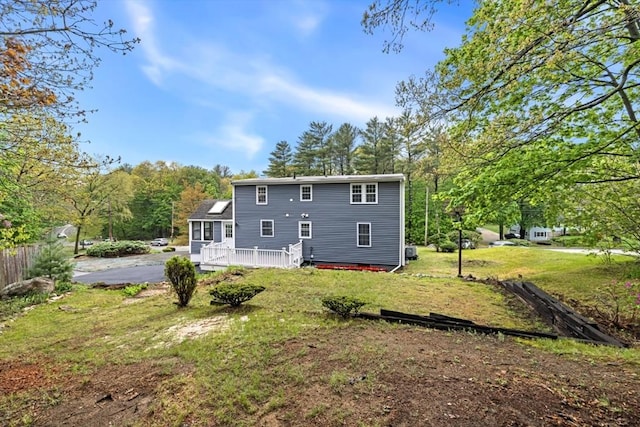 rear view of property with a yard and a deck