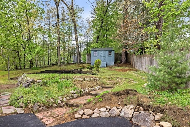 view of yard with an outbuilding, fence, and a storage unit