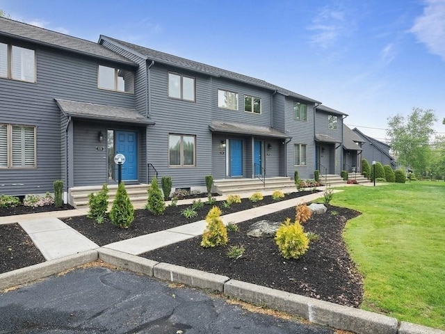 townhome / multi-family property with a front yard