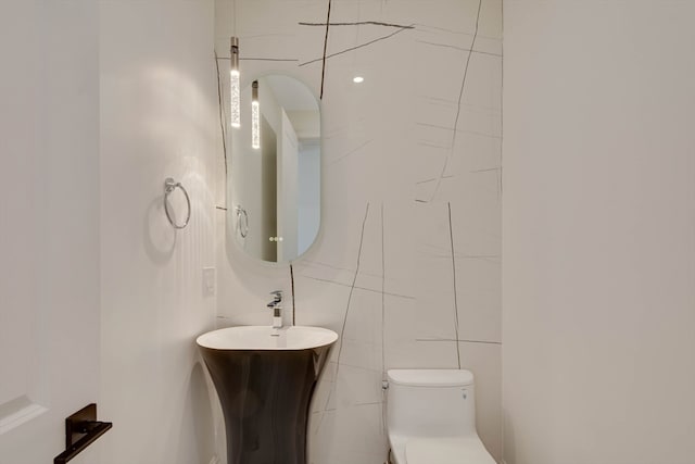 bathroom with tile walls and toilet