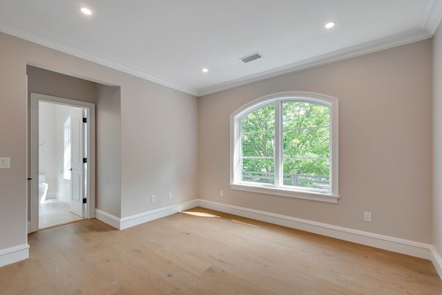 spare room with light wood-type flooring and ornamental molding