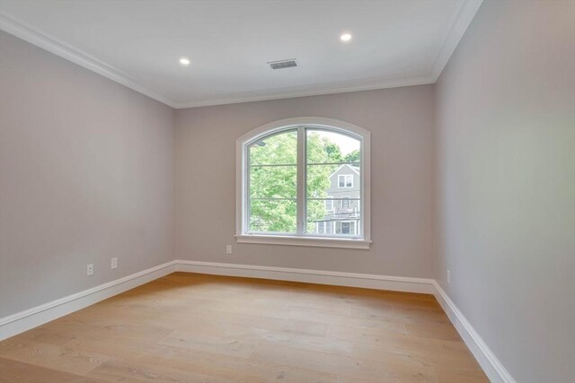 spare room with light wood-type flooring and ornamental molding