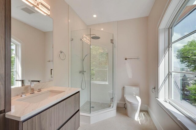 bathroom with vanity, toilet, and a shower with door