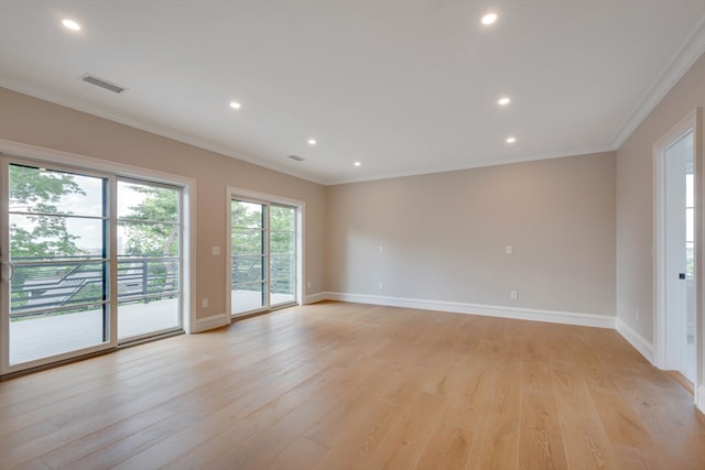 spare room with ornamental molding and light wood-type flooring