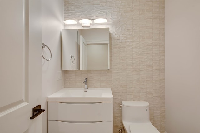 bathroom featuring decorative backsplash, toilet, and vanity