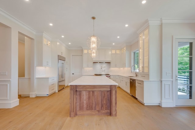 kitchen featuring pendant lighting, a center island, white cabinets, sink, and appliances with stainless steel finishes