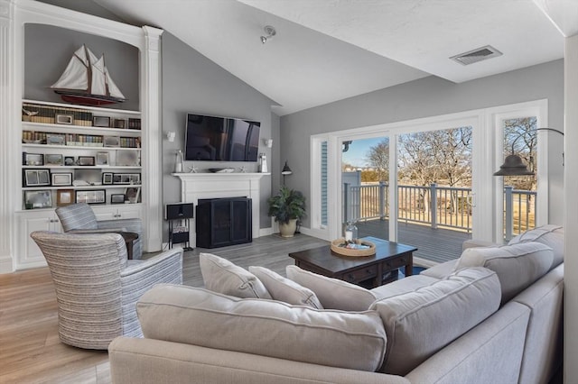 11 Fairway Dr Unit Oceanview, Plymouth, MA 02360 - living room with light wood finished floors, visible vents, vaulted ceiling, and a fireplace