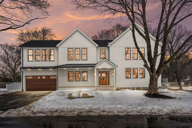 modern inspired farmhouse featuring driveway, metal roof, a standing seam roof, fence, and board and batten siding