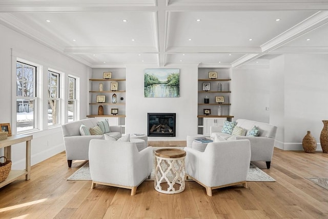 living room with baseboards, beamed ceiling, and light wood finished floors