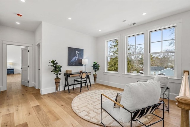 living area featuring baseboards, recessed lighting, visible vents, and light wood-style floors