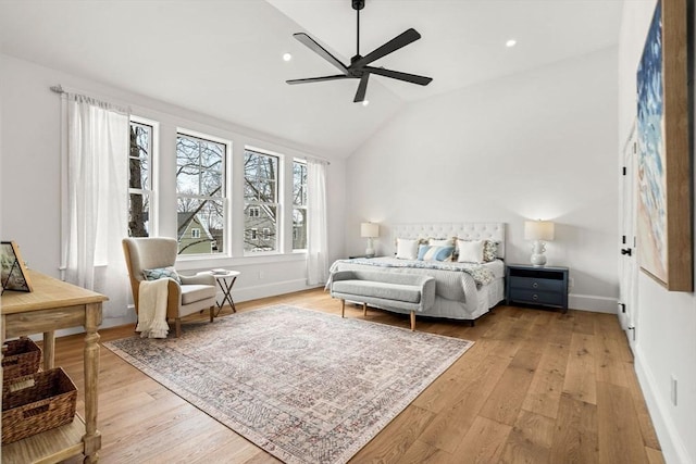 bedroom featuring light wood-style floors, vaulted ceiling, baseboards, and ceiling fan