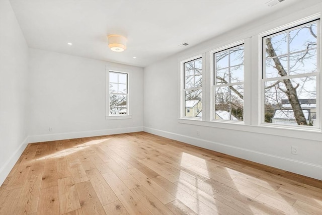 empty room featuring light wood-type flooring and baseboards