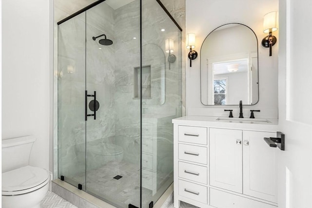 full bathroom featuring a stall shower, vanity, and toilet