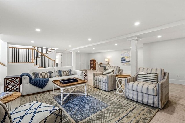 living area featuring stairs, recessed lighting, decorative columns, and light wood-style floors