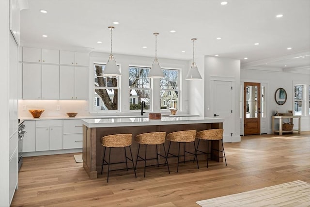kitchen with a large island, white cabinetry, light wood-style flooring, and recessed lighting