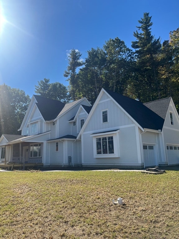 view of front of house with a front lawn, covered porch, and a garage